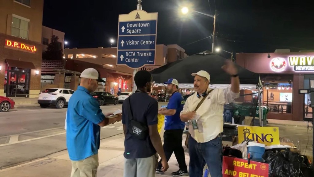 Street evangelism at night with King and Repent signs